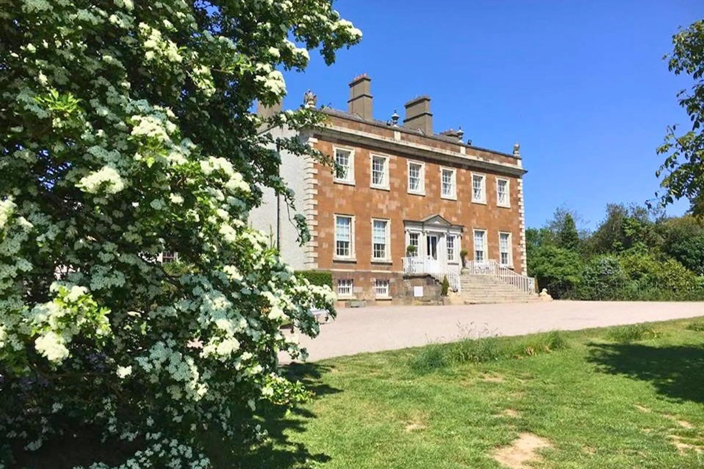 The Georgian facade of Newbridge House surrounded by green lawns